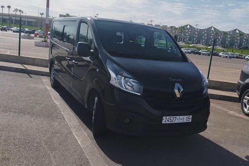 A black Renault van parked on a street with a clear sky and buildings in the background. 2