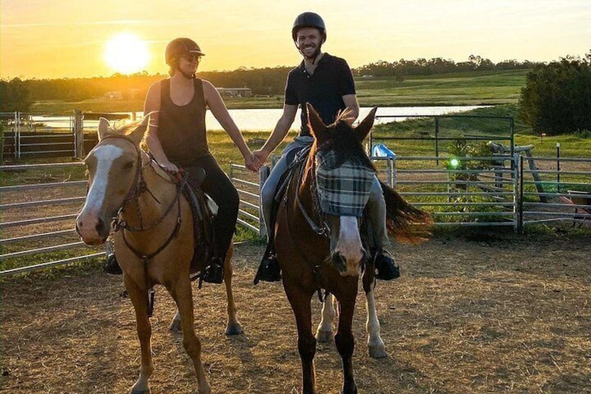 Deux personnes à cheval dans une arène en plein air, au coucher du soleil. 4