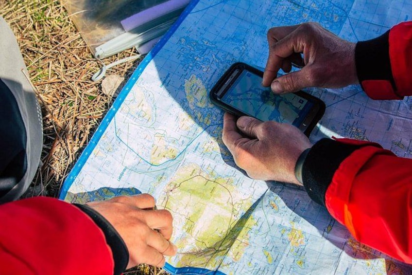 A person in a red jacket using a smartphone to interact with a map. 4