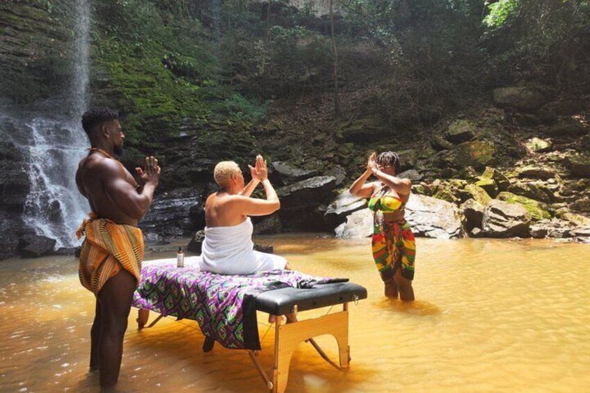 A person performing a yoga pose in a natural setting with a waterfall in the background. 4