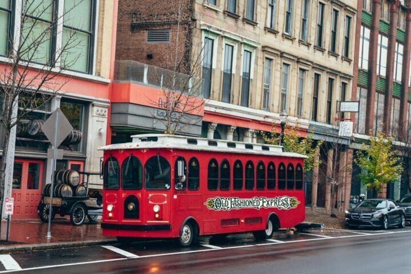 A red trolley labeled 'Old Fashioned Express' on a city street. 2