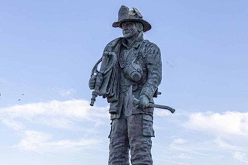 A statue of a soldier in uniform with a rifle and a hat. 4