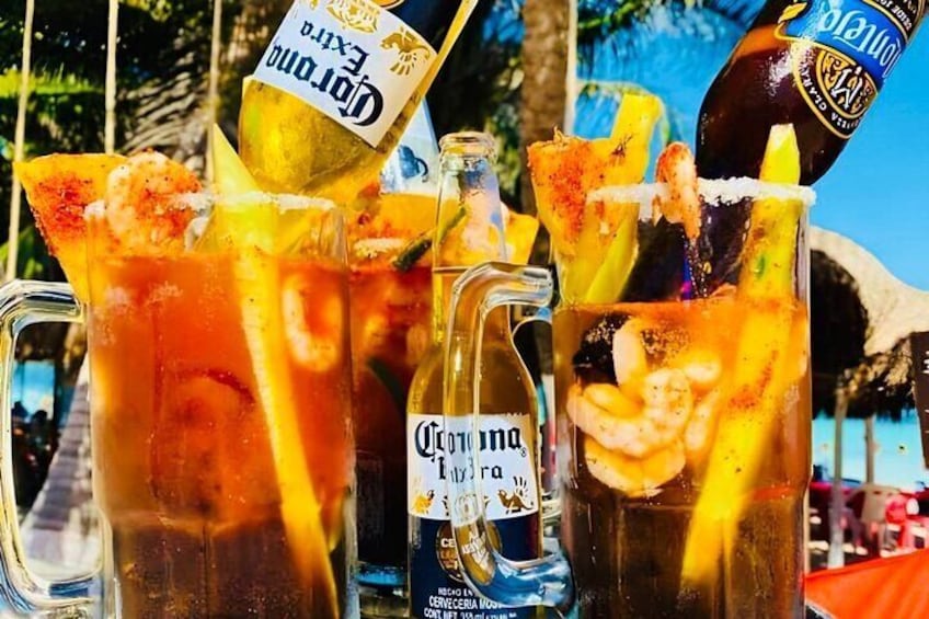 Tres vasos grandes de cerveza con hielo y adornos, una botella de Corona Extra y una botella de Corona Negra. 1