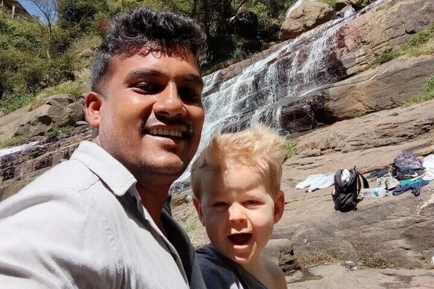 A person taking a selfie with a waterfall in the background. 2