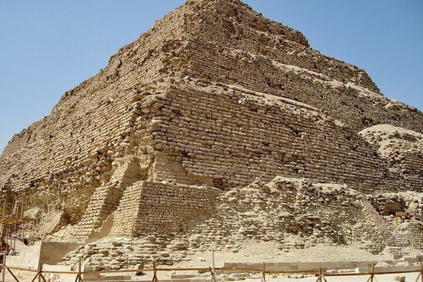 A large pyramid with a stepped structure, surrounded by a sandy area. 4