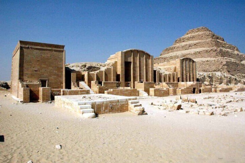 Ancient ruins with stepped pyramids and stone structures. 1