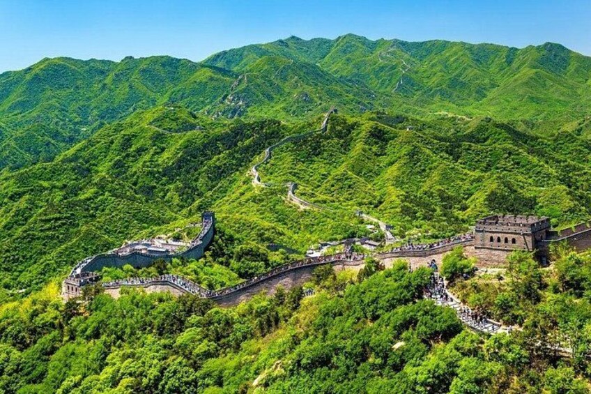 The Great Wall of China winding through lush green mountains. 3
