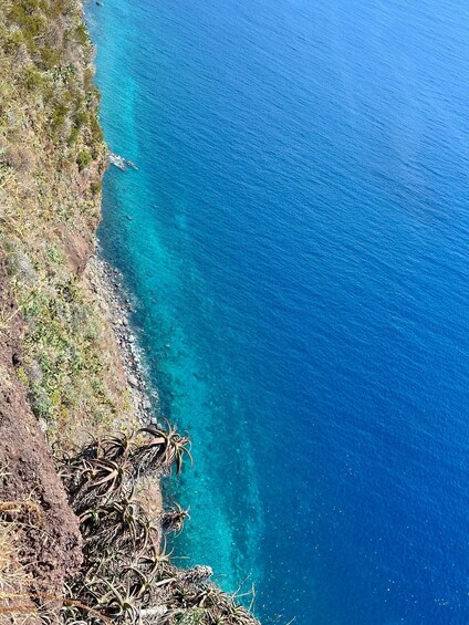 A coastal landscape with clear blue waters and rocky terrain. 3