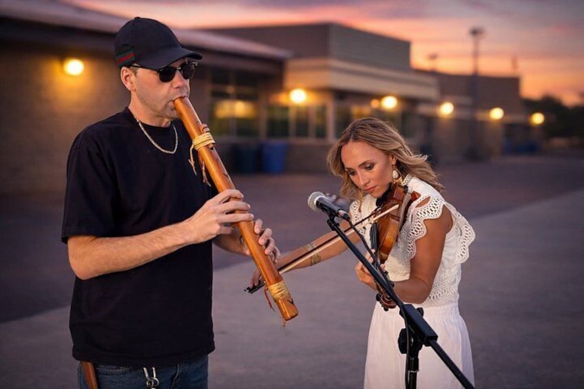 A person playing a flute and another person playing a violin. 2