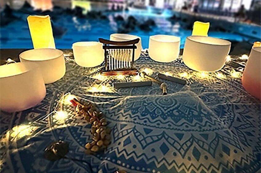 A table with candles, a patterned tablecloth, and a decorative centerpiece. 3
