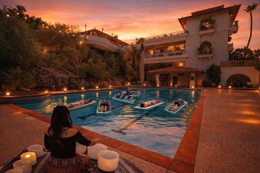 A pool with boats, a person sitting with cups, and a building in the background. 1