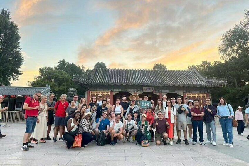 Un grupo de personas posando frente a un edificio tradicional con tejado de tejas y un letrero. 3