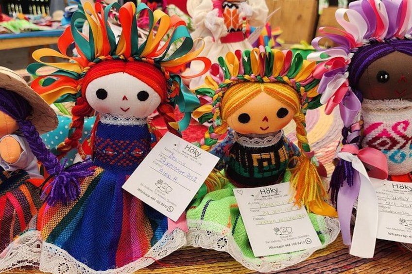 A collection of colorful dolls with detailed clothing and accessories, displayed on a table. 4