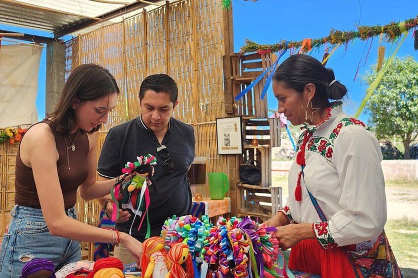 A market stall with colorful textiles and a bamboo structure in the background. 1