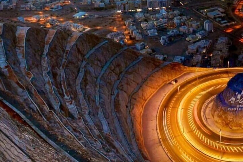 A large open-pit mine with circular roads and a building labeled "PHOTOG". 2