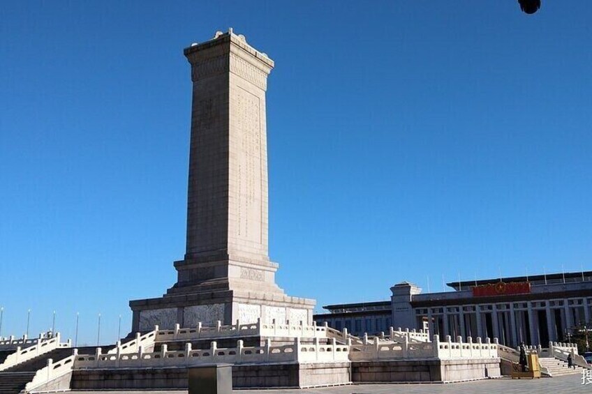 A tall, narrow monument with inscriptions, surrounded by a stone platform and steps. 5