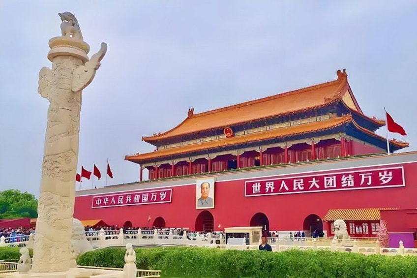 A traditional Chinese building with a red roof and a statue in the foreground. 1