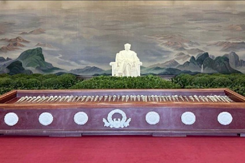 A statue on a pedestal with a mountainous landscape in the background. 3