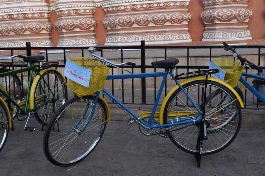 A blue bicycle with a yellow basket and a yellow tag attached to the front. 3