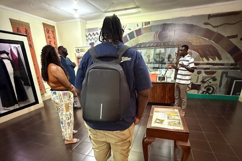 Un musée situé à l’intérieur d’un bâtiment, avec des expositions, un homme portant un sac à dos et une femme vêtue d’un pantalon à motifs. 4