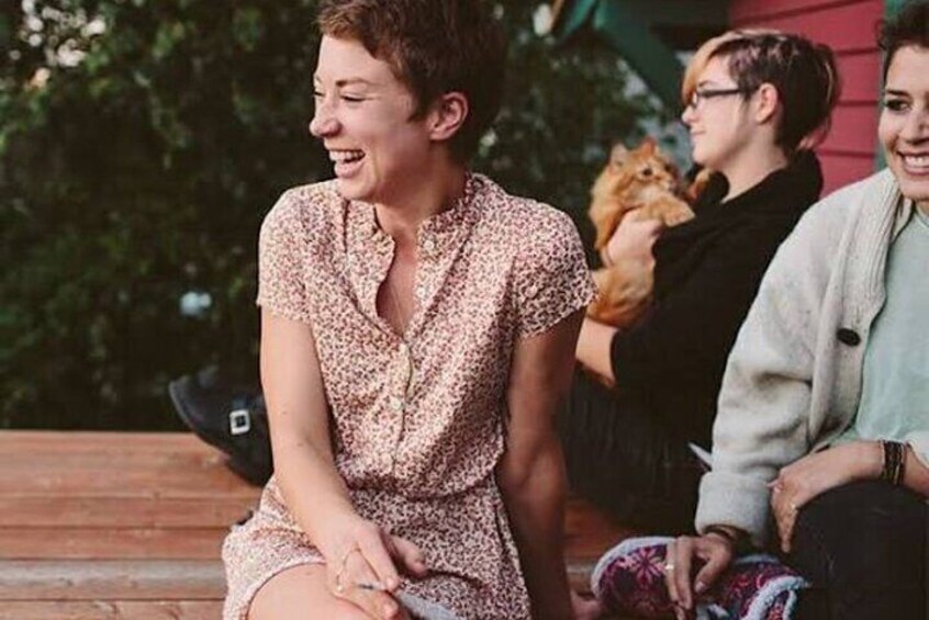 A person sitting on a wooden bench outdoors. 3
