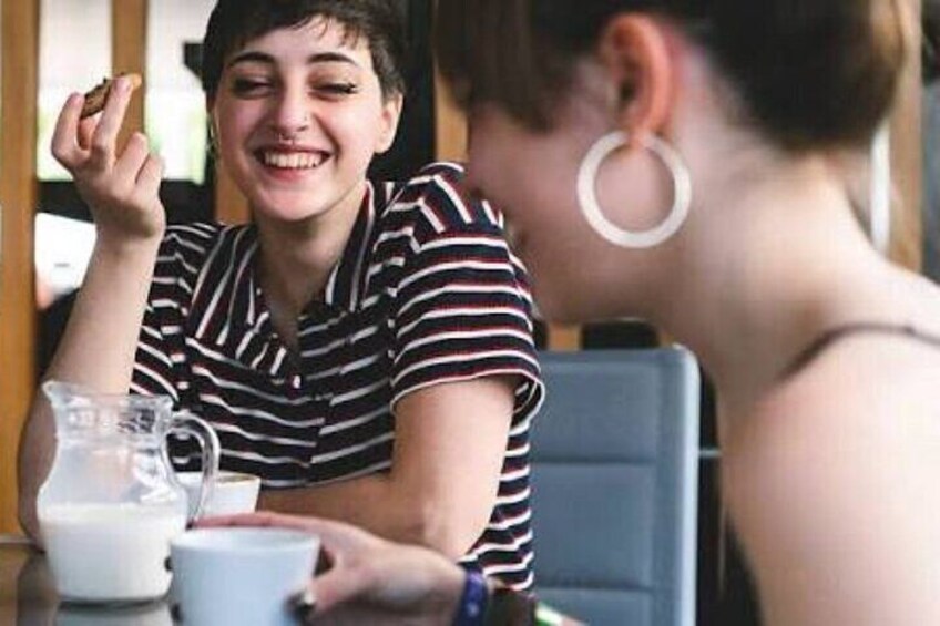 A person sitting at a table with a cup of coffee and a glass of milk. 2