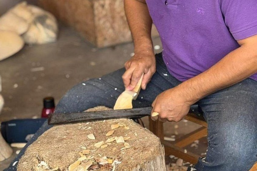 Una persona utilizza un utensile manuale per lavorare su un oggetto in legno. 1