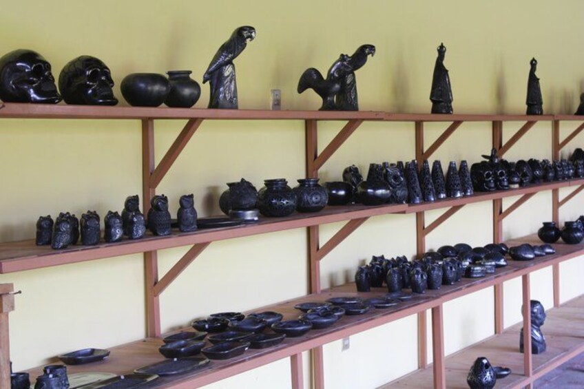 Shelves with various black ceramic items, including pots, vases, and sculptures. 2