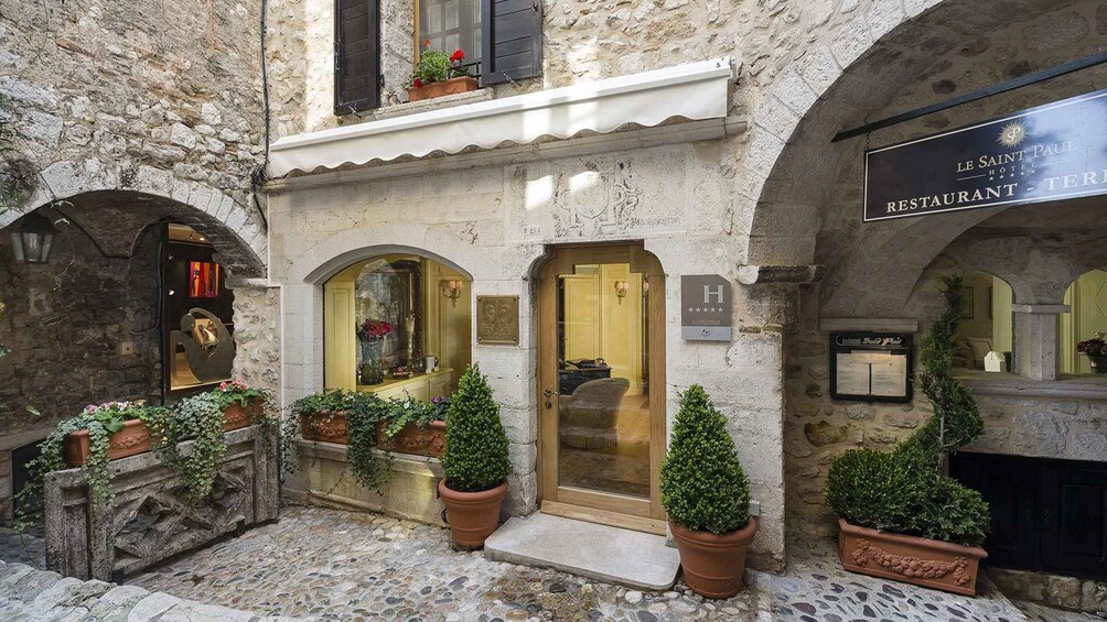 A stone building with a sign for Le Saint Paul Hotel and Restaurant. 3