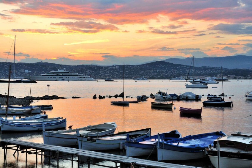 A marina with various boats docked at the pier during sunset. 4