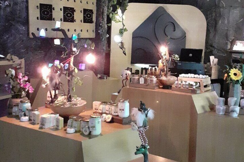 A room with a table displaying various items including a laptop, candles, and decorative objects. 5