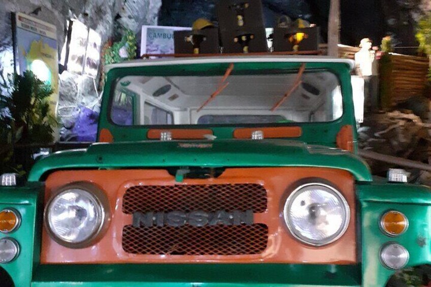 A green and orange Nissan pickup truck with a spare tire mounted on the back. 2