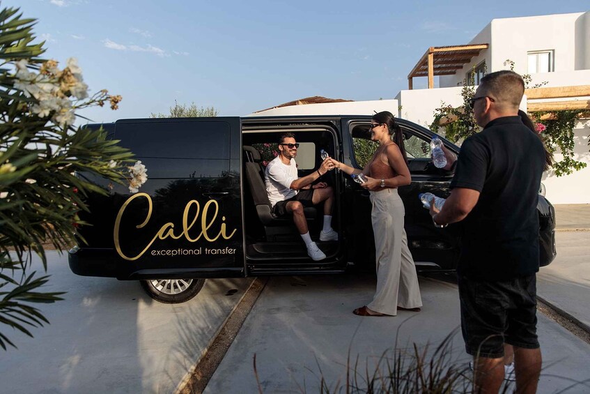 A black van with 'Calli exceptional transfer' written on the side parked on a street. 1