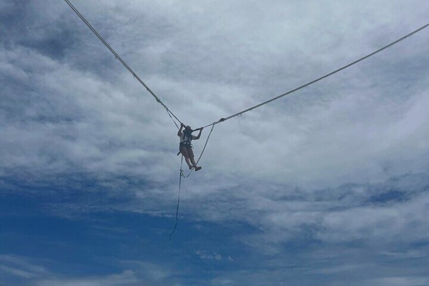 Una persona suspendida en el aire con una cuerda elástica, sobre un cielo nublado. 5