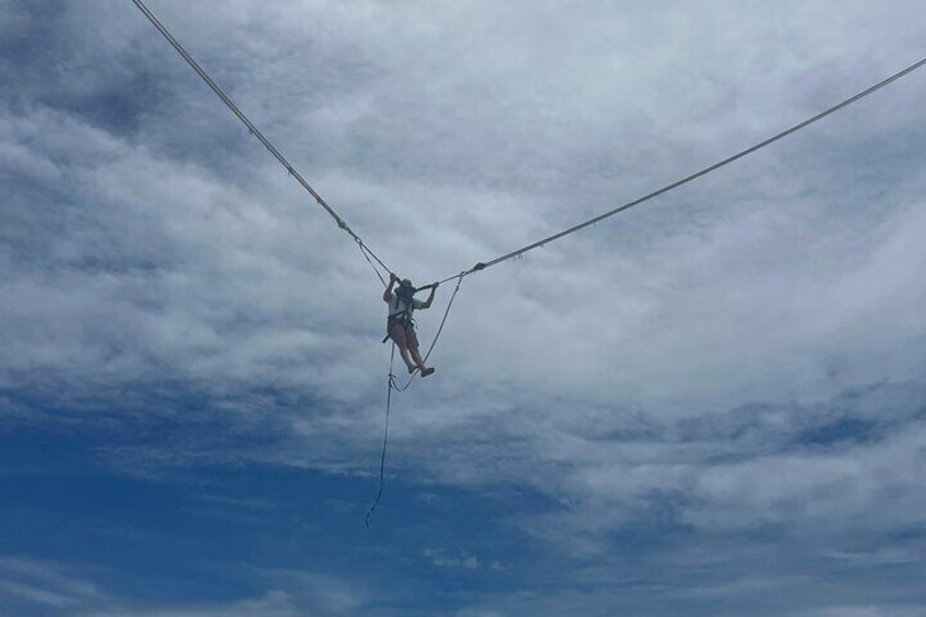 Una persona colgada entre dos cables bajo un cielo nublado. 4