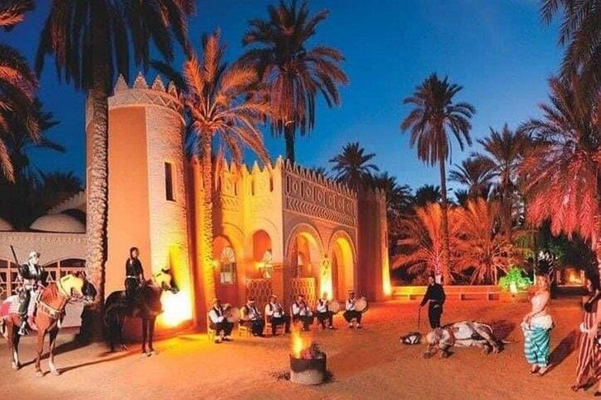 A historical building with arches and palm trees. 4