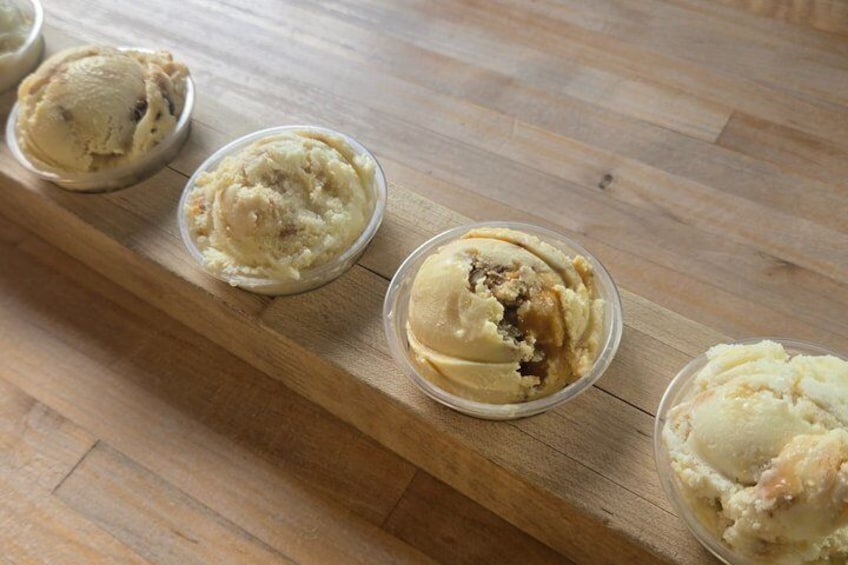 Four containers of ice cream on a wooden tray. 2