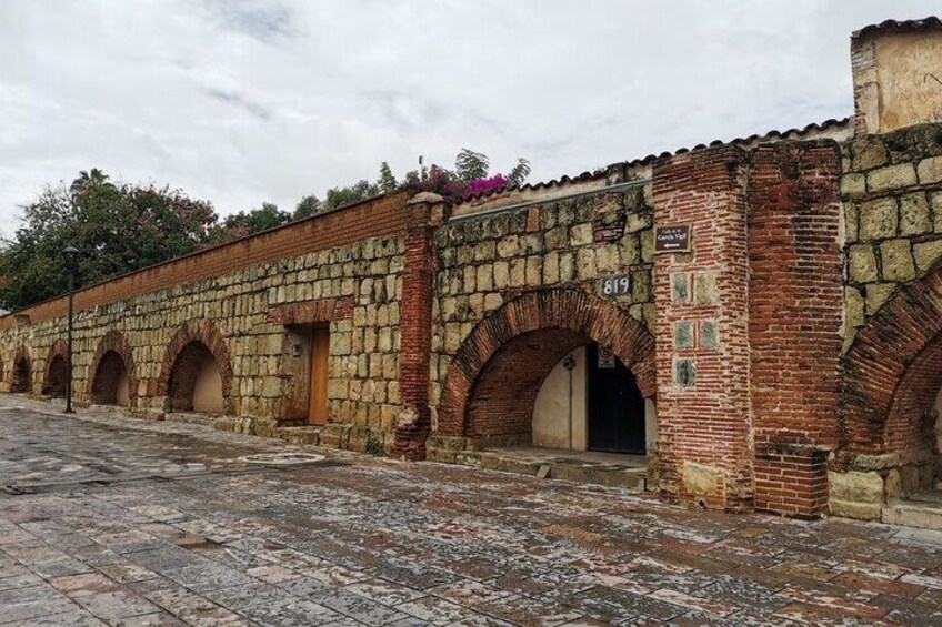 A stone building with arched doorways and a brick facade. 1