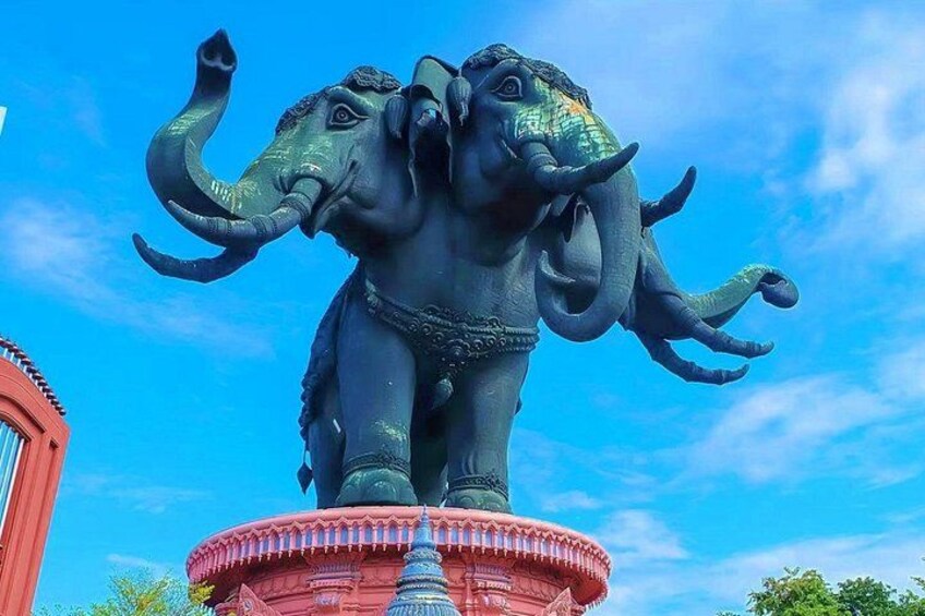 A bronze elephant statue on a red pedestal with a clear blue sky in the background. 1