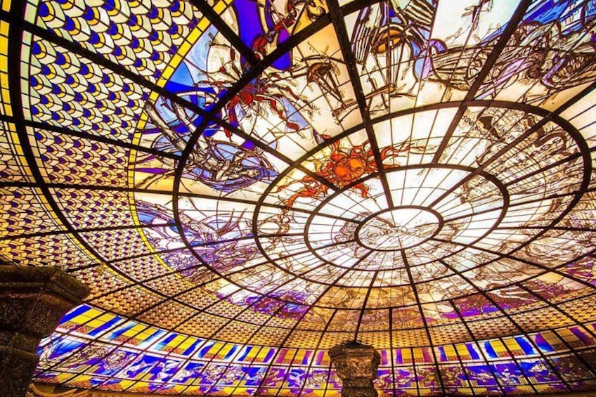 A stained glass ceiling with intricate patterns and a central circular design. 5