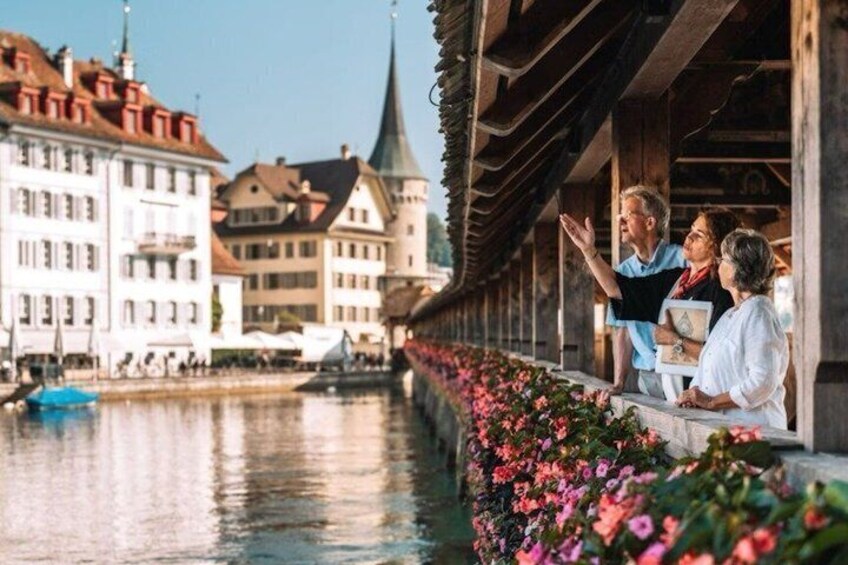 A riverside walkway with buildings and a church spire in the background. 2