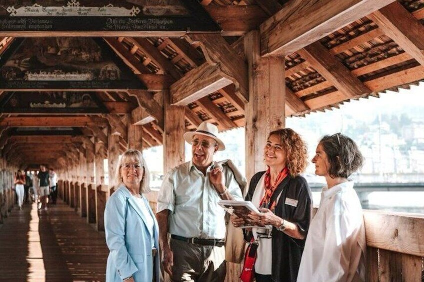 A wooden covered walkway with people standing and conversing. 5
