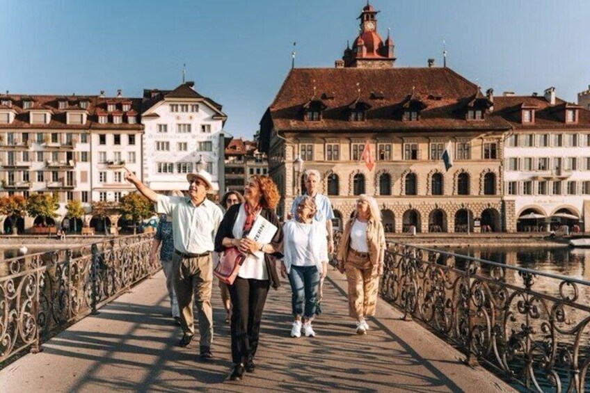 A group of people walking on a bridge with buildings in the background. 3