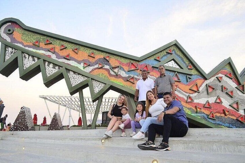 A group of people posing in front of a colorful, geometric sculpture. 4