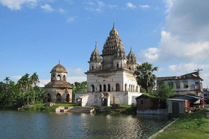 A historic temple complex with domed structures by a river. 1