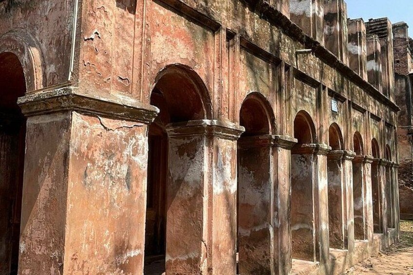 A weathered building with arched windows and columns. 3