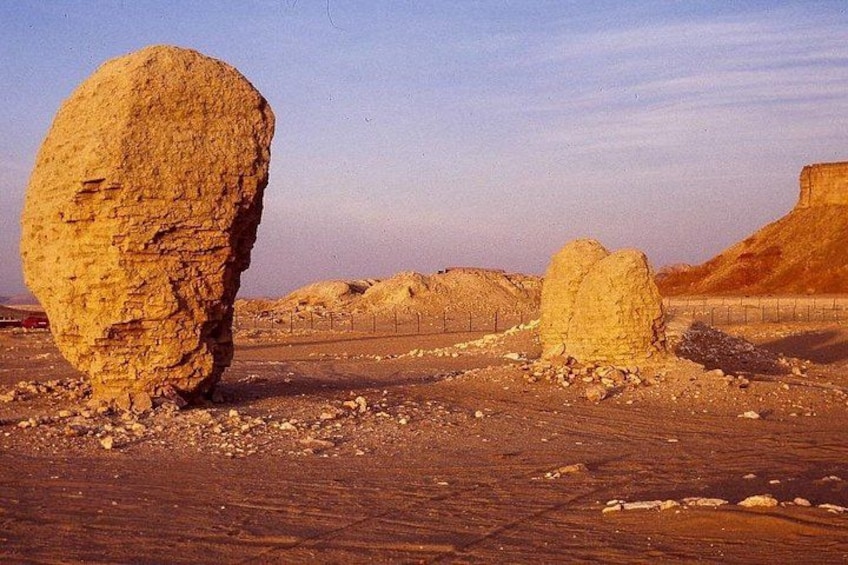 Paisaje desértico con grandes formaciones rocosas y una colina distante. 5