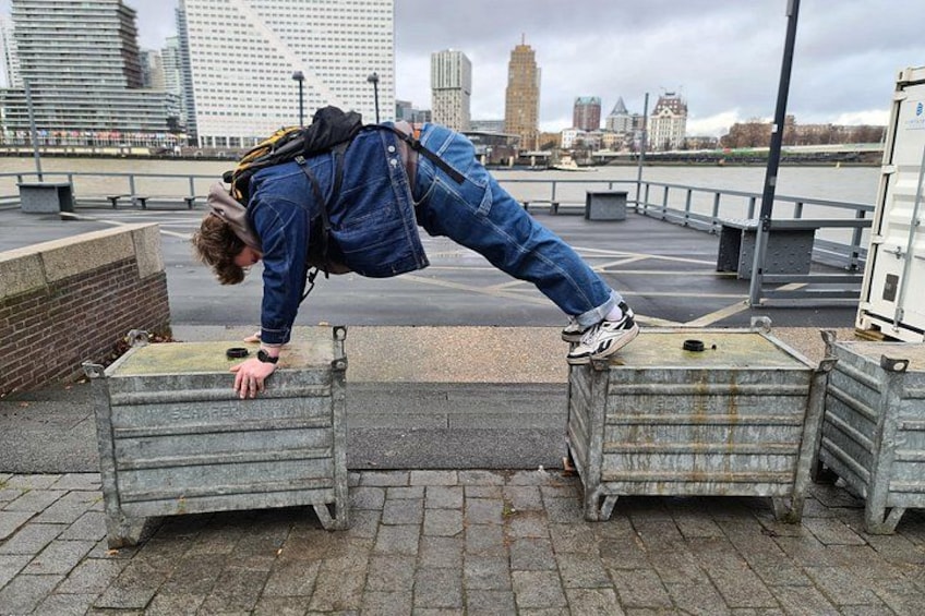 A person performing a handstand on a ledge with a cityscape in the background. 4