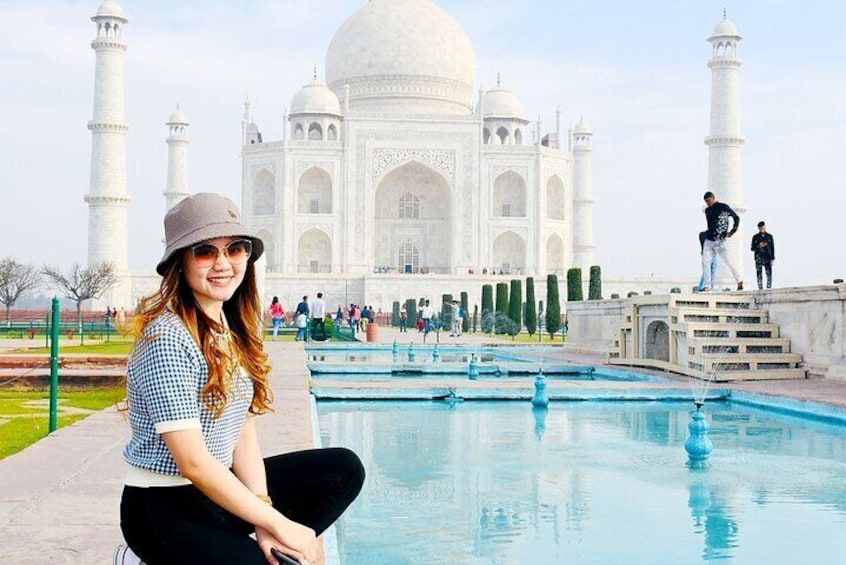 Eine Person sitzt am Pool, mit dem Taj Mahal im Hintergrund. 5