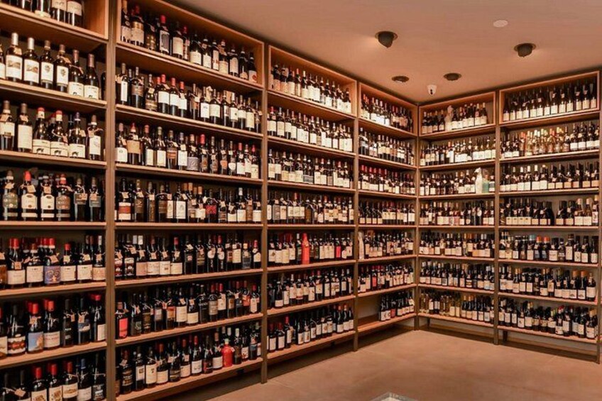 A large wine cellar with numerous shelves stocked with wine bottles. 3